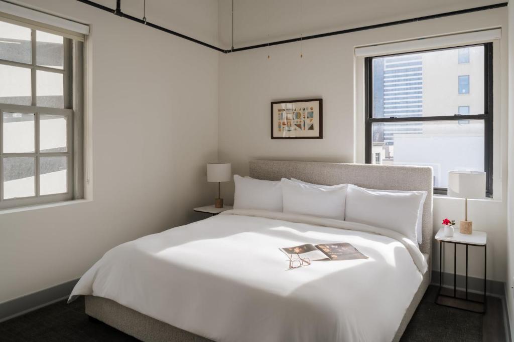 een slaapkamer met een wit bed met daarop een boek bij Kasa Capitol Hill Downtown Nashville in Nashville