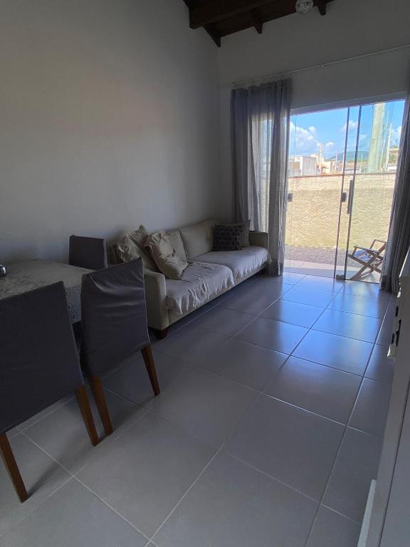 Una sala de estar con un sofá y una ventana grande. en Casa com Piscina em Itapirubá, en Imbituba