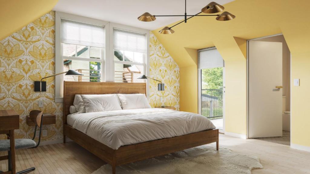 a bedroom with a bed with yellow walls and windows at The Einstein Room in Boise