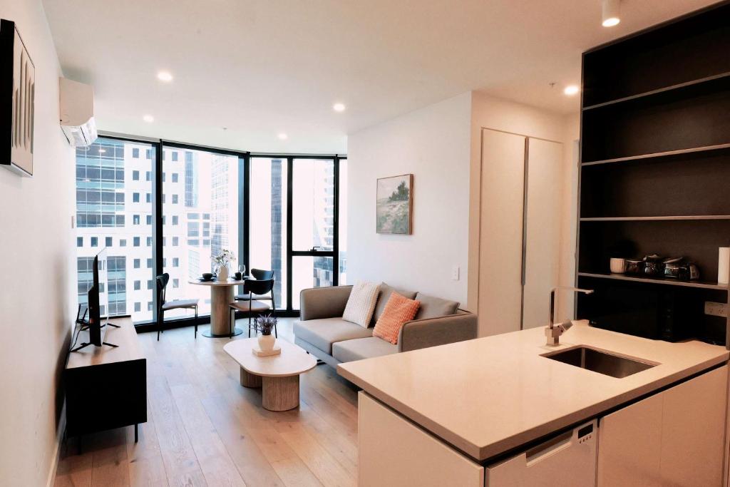 Una cocina y una sala de estar con un sofá y una mesa. en 1Br City View apt near SthnCrs Wifi Pool Gym, en Melbourne