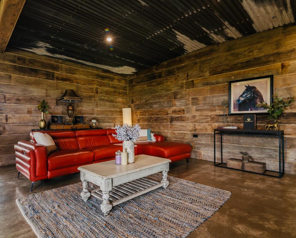 Bridge Moore Lodge في Bucca: غرفة معيشة مع أريكة حمراء وطاولة