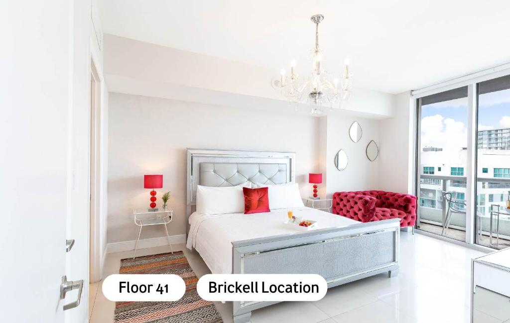 Dormitorio blanco con cama y sofá rojo en MVR Bright & Airy Condo with Views, en Miami
