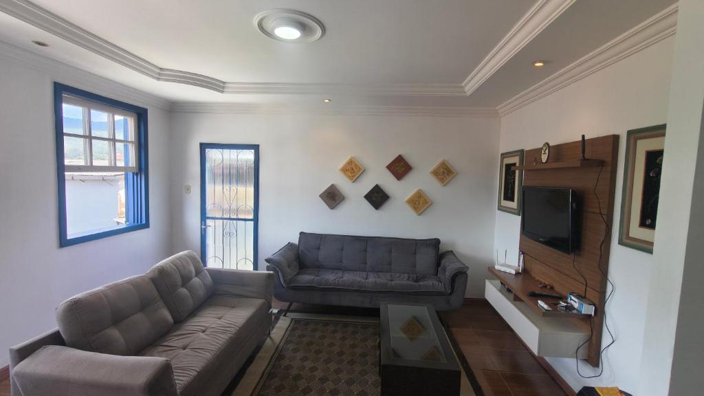 Excelente Apartamento em Casarão Histórico في ماريانا: غرفة معيشة مع أريكة وتلفزيون