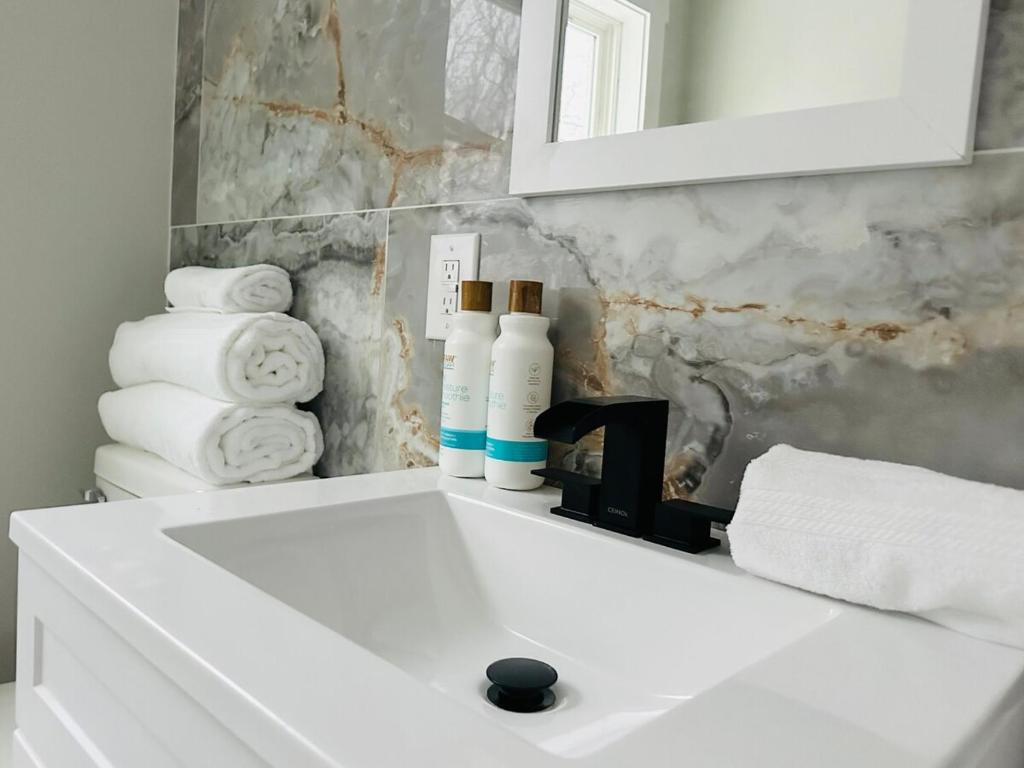 un bancone del bagno con lavandino bianco e asciugamani di Blue Ridge Main St Mountain View Cottage a Sparta