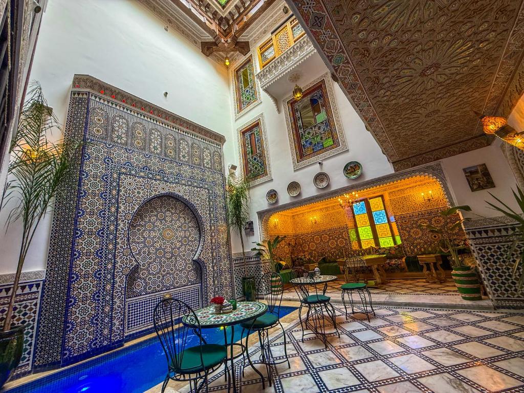 a room with tables and chairs in a building at Riad Dar El bellar in Fès