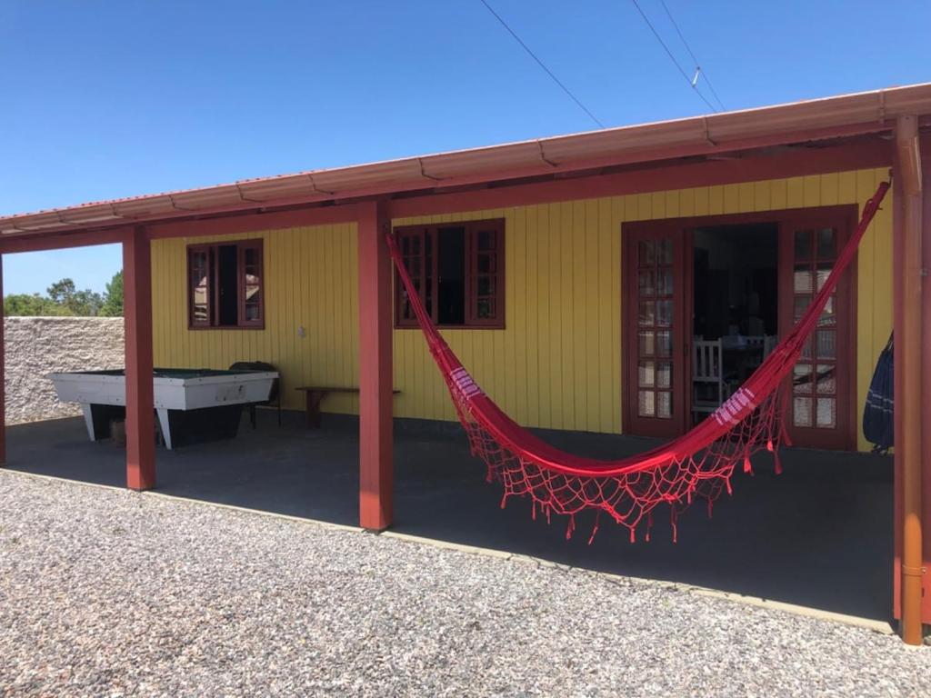 A melhor Casa na praia para temporada في باليوسا: منزل أصفر أمامه أرجوحة