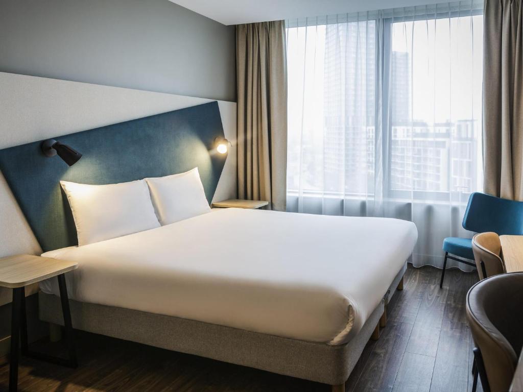 a hotel room with a bed and a large window at Aparthotel Adagio London Stratford in London