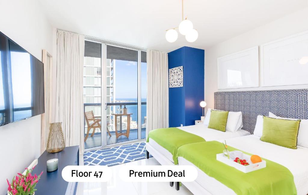 Una habitación de hotel con dos camas y balcón. en MVR - Wake to Water & Skyline Views, en Miami