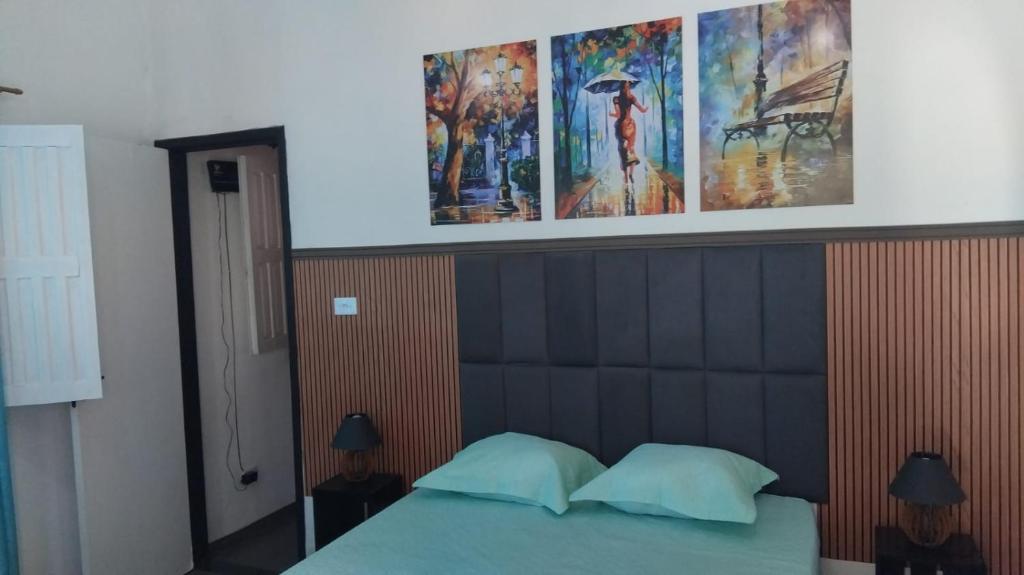 a bedroom with a bed with a large head board at Vila mar azul in Imbassai