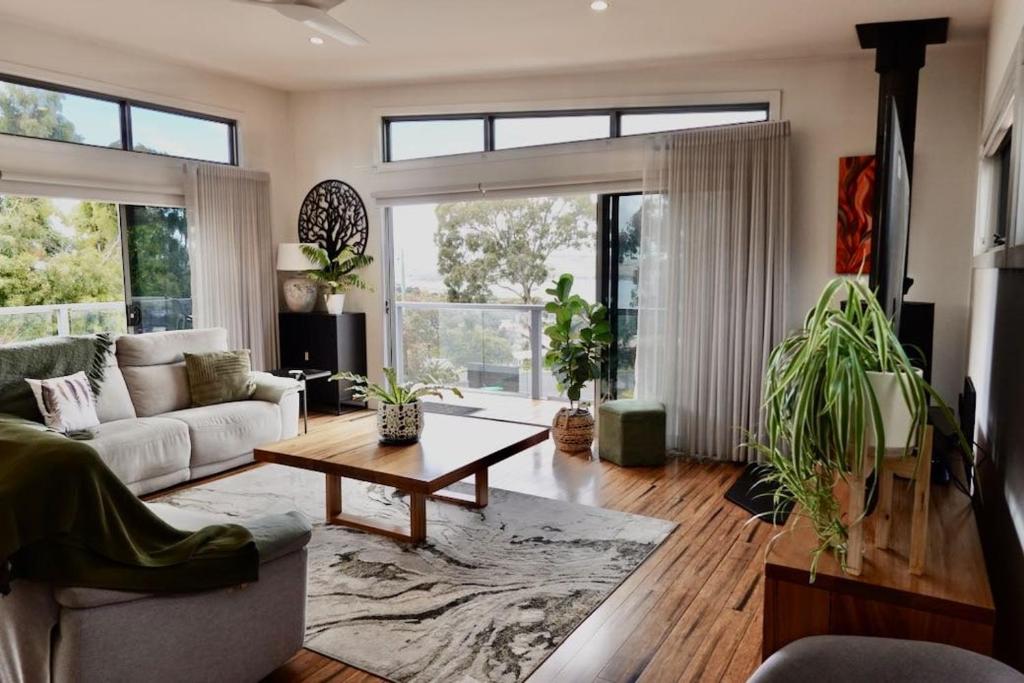 a living room with a couch and a table at Paradise - Spacious, Ocean Views, Outdoor Living in Dodges Ferry