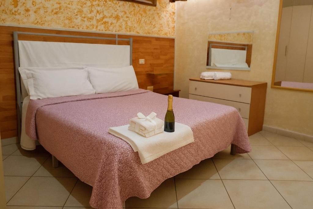 a bedroom with a bed with a bottle of wine at Bed and Breakfast La Primavera NOLA in Nola