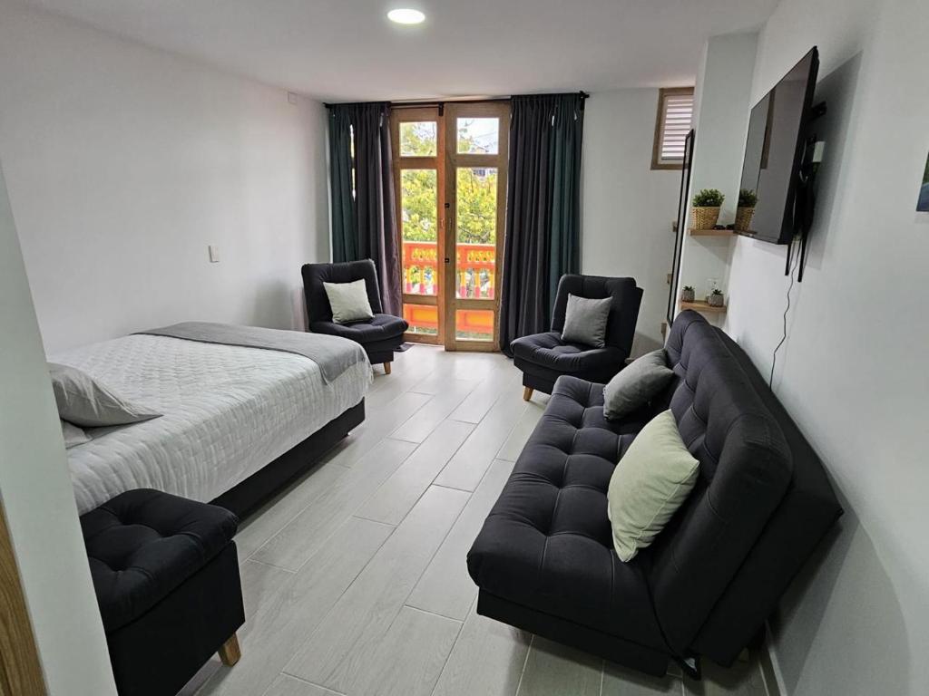 a bedroom with a bed and a couch and chairs at Girasoles del parque in Estación El Salto