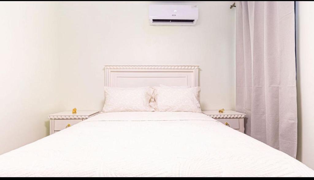 a white bed with white sheets and pillows at Caribbean Breeze in Punta Cana