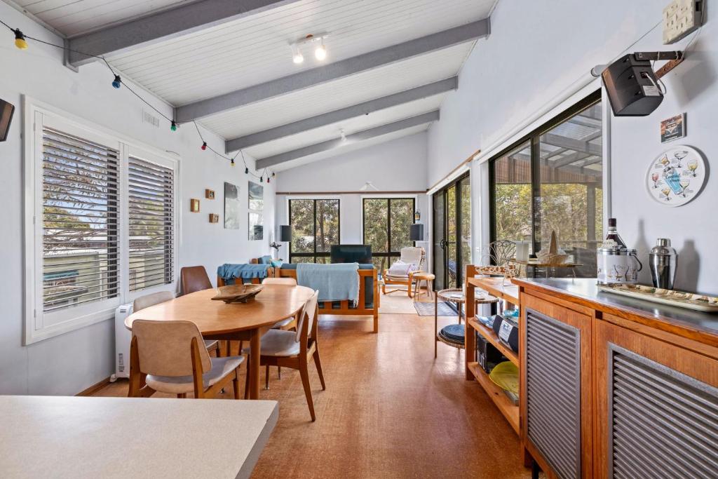 a kitchen and dining room with a table and chairs at Treehouse at Cape in Cape Paterson