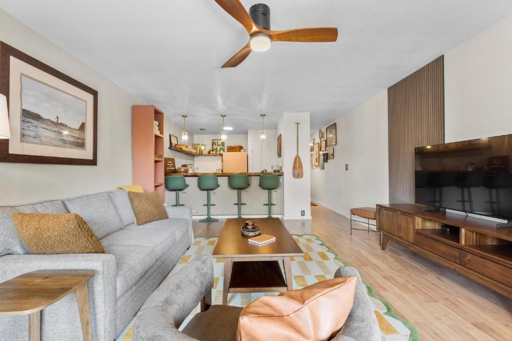a living room with a couch and a tv at The Landing at Kailua Bay in Kailua-Kona