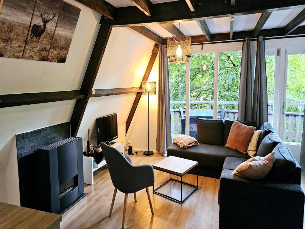 uma sala de estar com um sofá e uma TV em Relaxing Ardennes Getaway in Durbuy em Septon