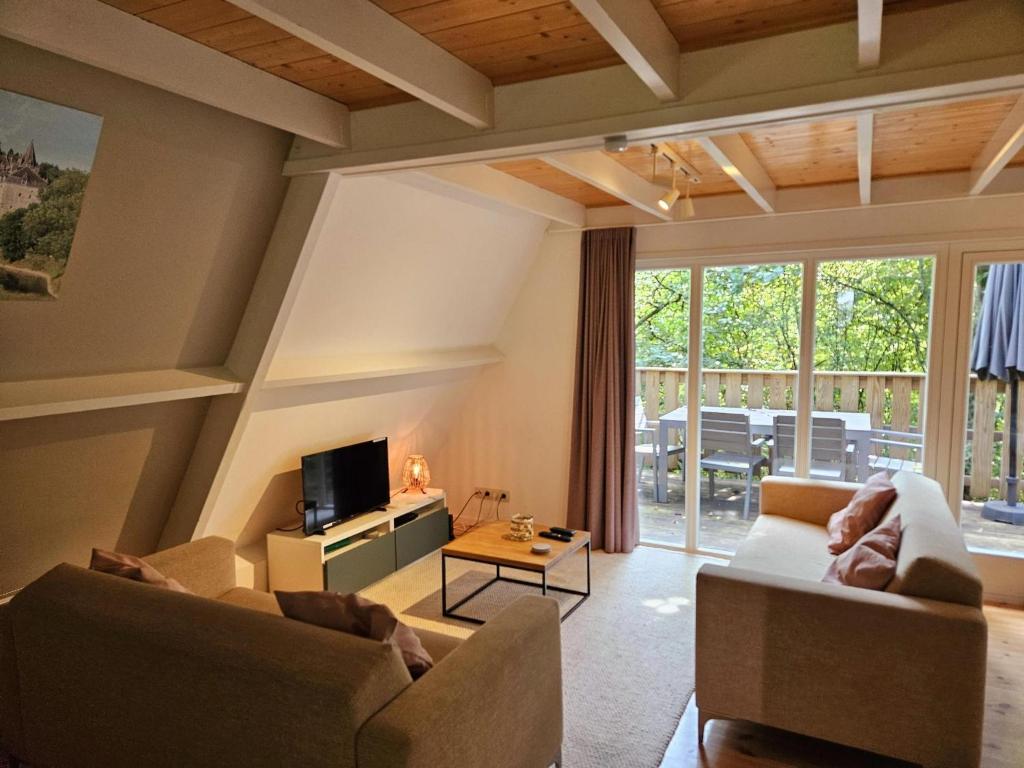 uma sala de estar com dois sofás e uma TV em Lovely Private Chalet near Durbuy em Septon