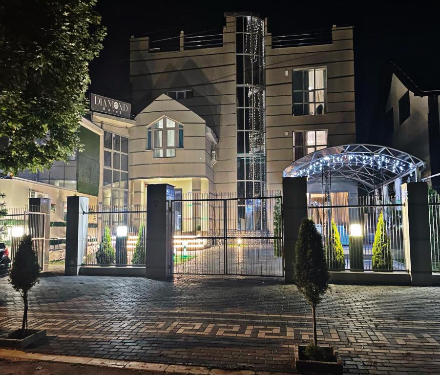 a building with a gate at night at Diamond Hotel in Chişinău