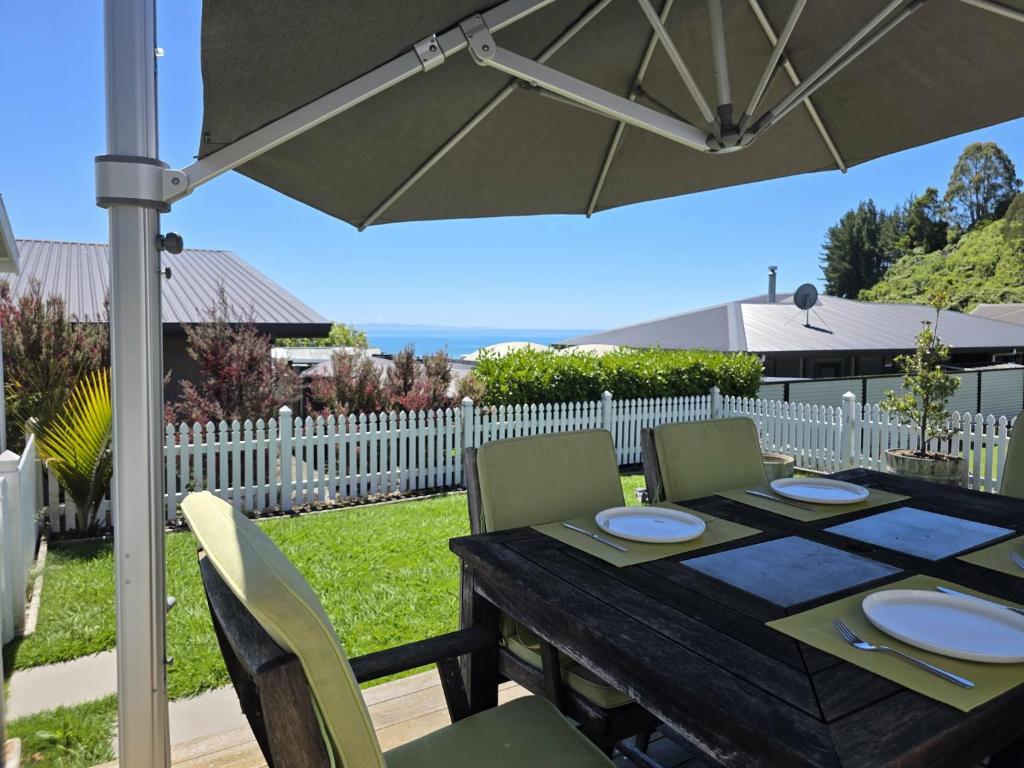 a wooden table with chairs and an umbrella at Time Out in Pohara in Pohara