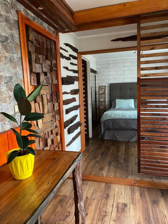 a bedroom with a bed and a plant on a table at Centro de Temuco Depto único, rústico y a pasos de todo Incluye estacionamiento in Temuco
