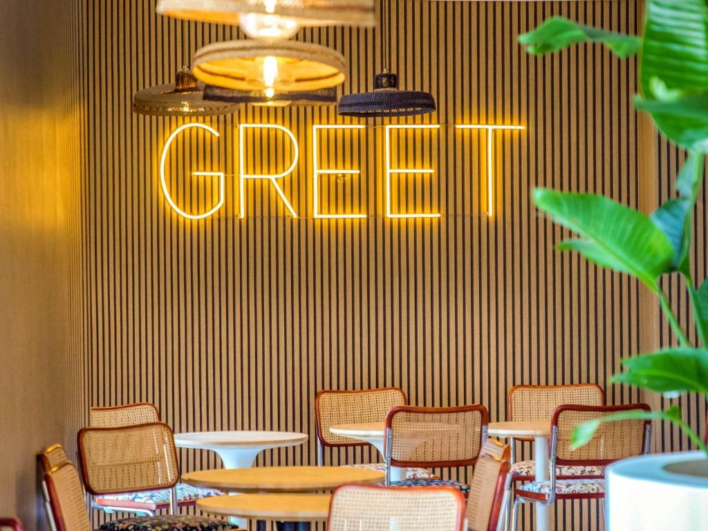 greet hotel Salon de Provence في صالون دو بروفانس: مطعم به كراسي وطاولة ولافتة مكتوب عليها سرطان البحر