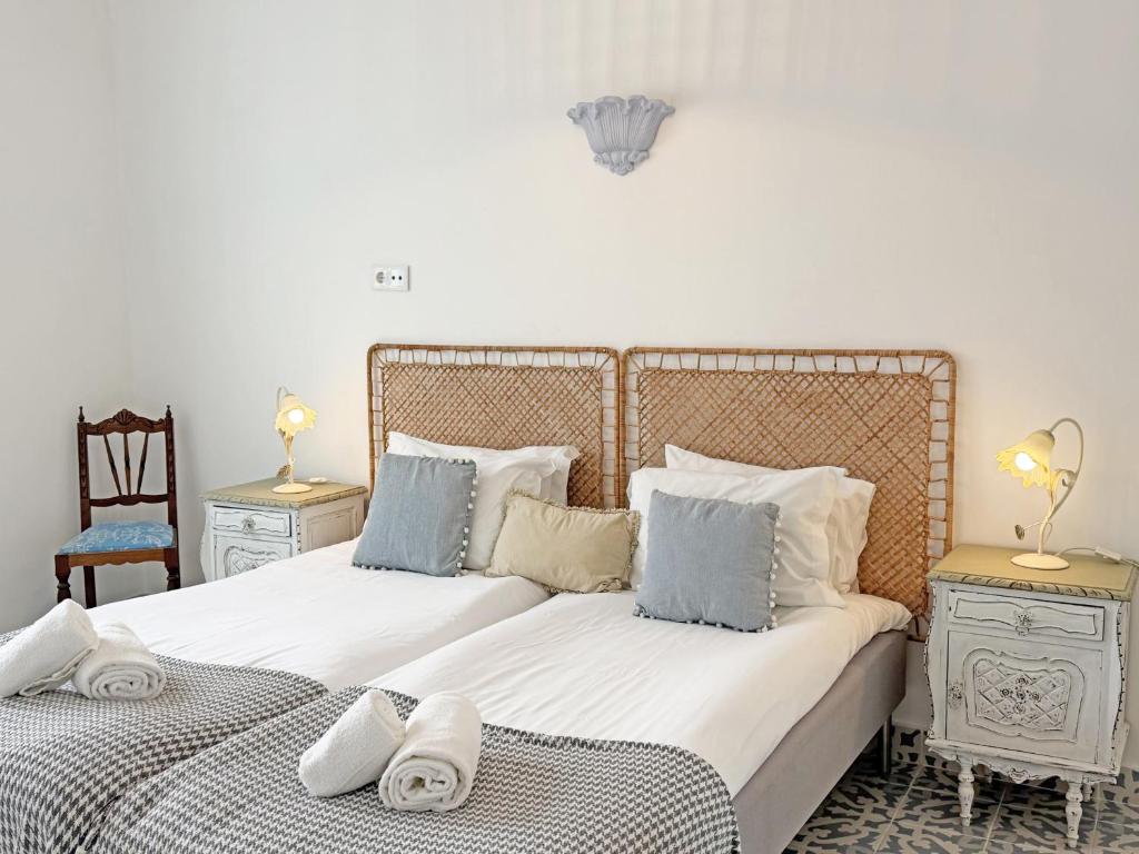 een slaapkamer met twee bedden met handdoeken erop bij Casa Florence - Fuseta in Fuzeta