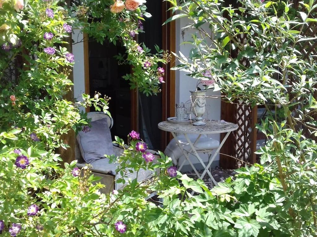 Mathilde Comfortable holiday residence في بوكِنغ: طاولة وكراسي في حديقة بها زهور