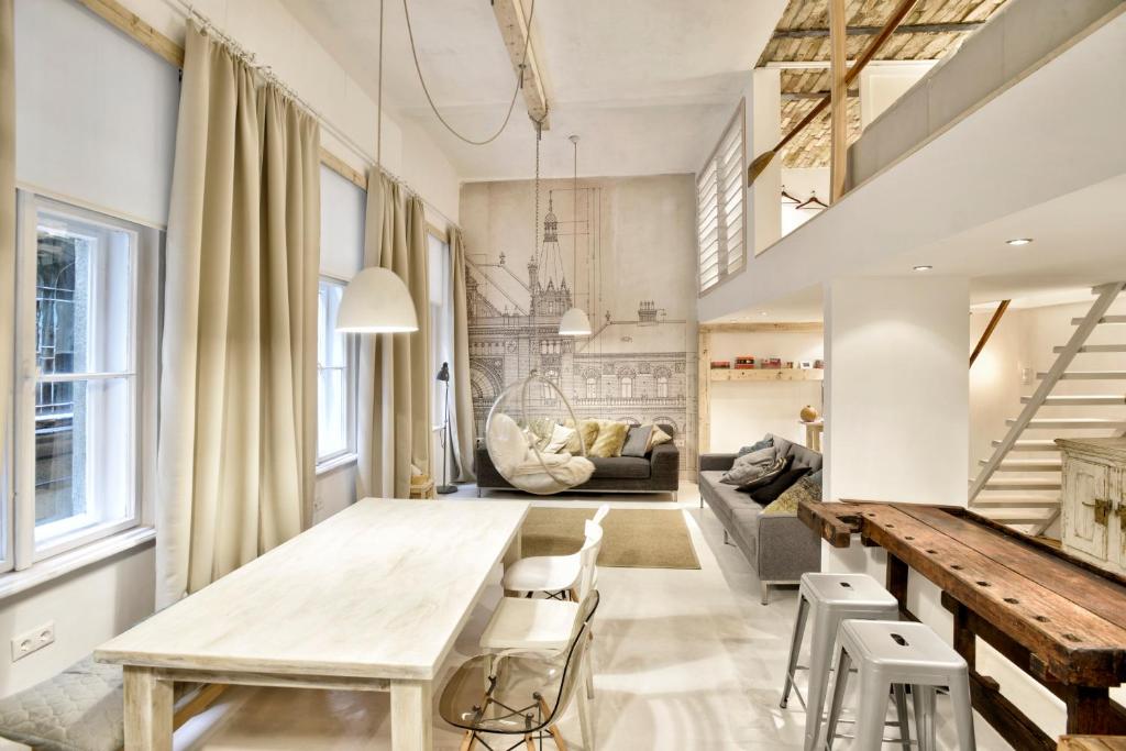 布達佩斯的住宿－設計師- A10公寓，一间带桌椅和沙发的用餐室