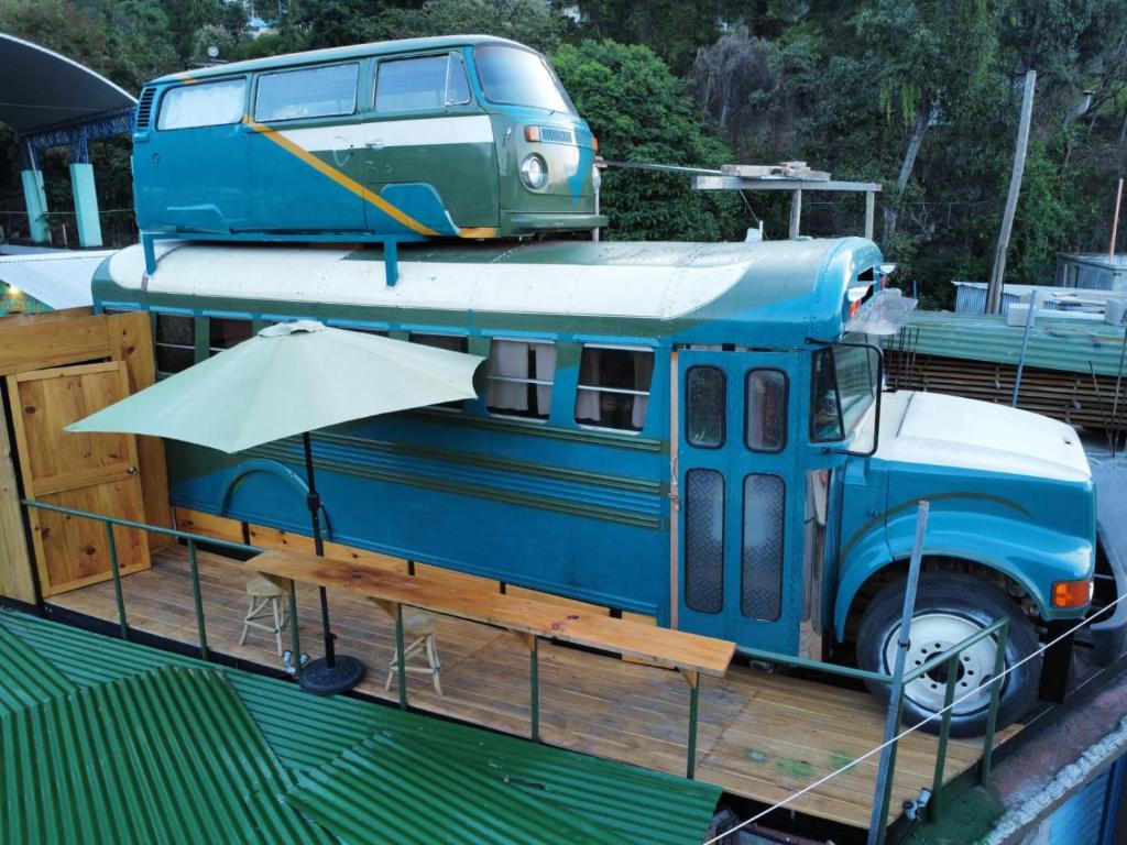an old blue bus sitting on top of a boat at Rooftop Converted School Bus in San Marcos La Laguna