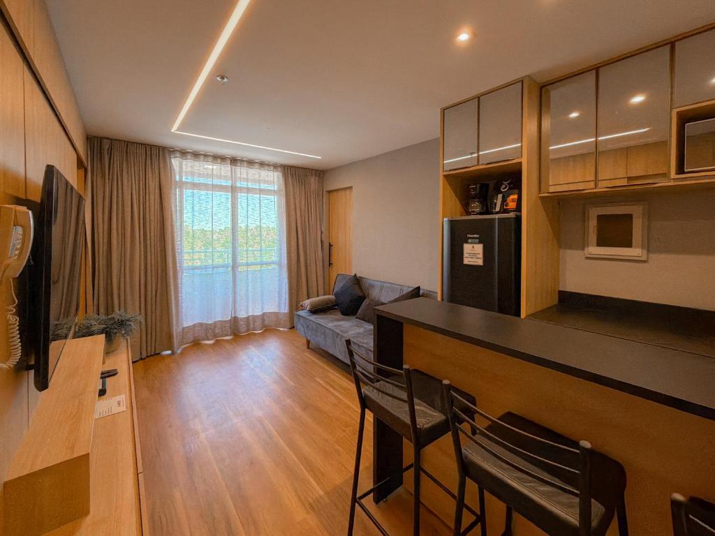 a living room with a couch and a kitchen with a bar at Apto Luxo Gran Lençóis Atins 503 in Barreirinhas