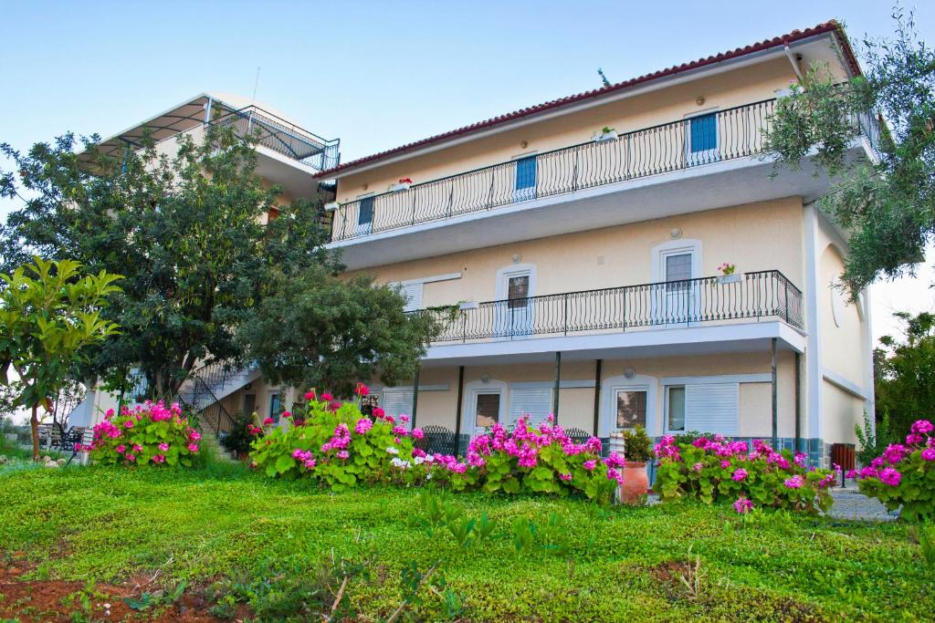a building with flowers in front of it at Alonia Studios & Maisonettes in Tolo