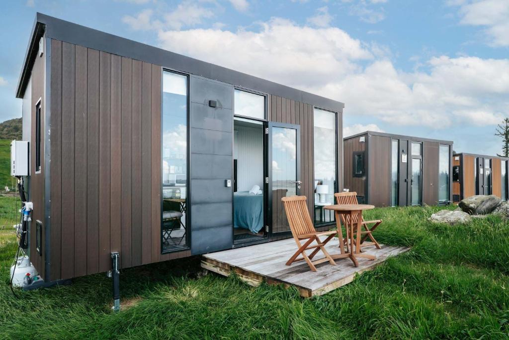 a tiny house with two chairs and a table at Aorangi Peak Cabins 7 by Tiny Away in Rotorua