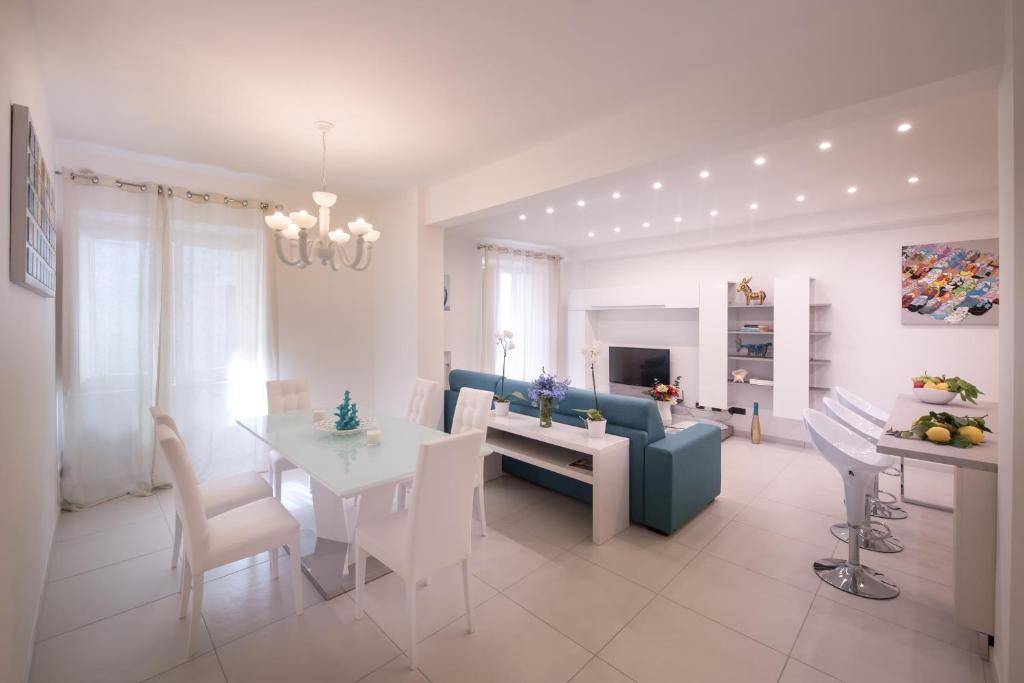 ein Wohnzimmer mit einem Tisch und einem blauen Sofa in der Unterkunft Al Corso Apartments by AMALFIVACATION in Minori
