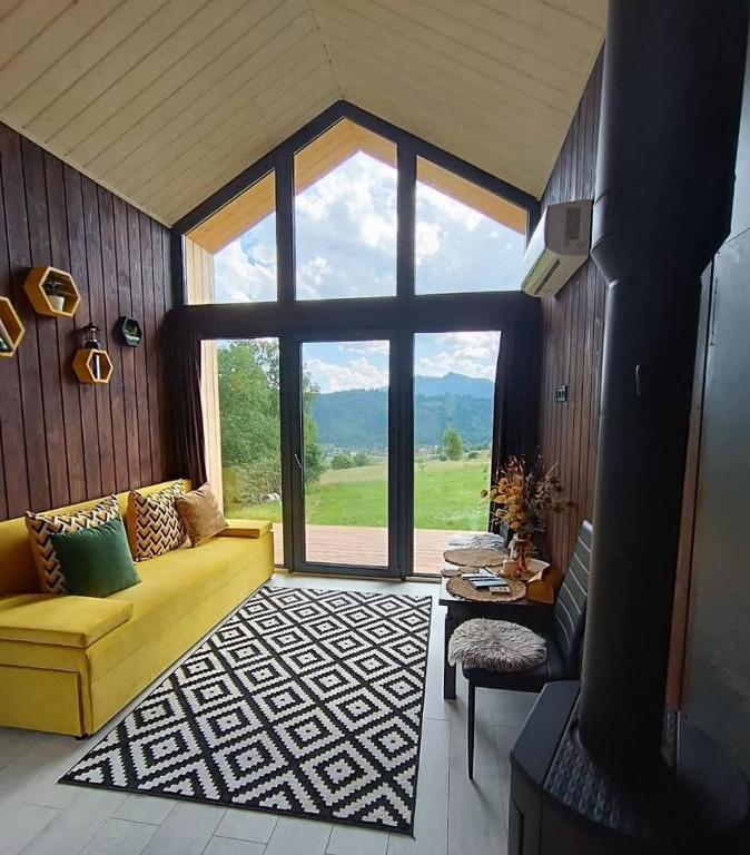 a living room with a yellow couch and a large window at Feeling Freedom in Tukhlya
