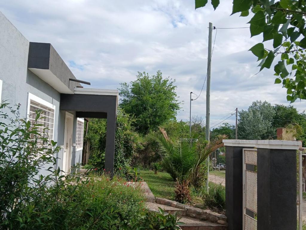 a house with a gate in front of a yard at Aguaribay in Villa Los Aromos