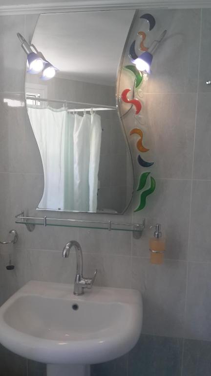 a bathroom with a sink and a mirror at Elisabeth Villas in Kerveli