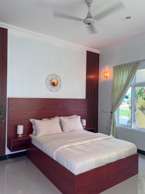 a bedroom with a large bed and a window at Filladhoo inn in Filadu