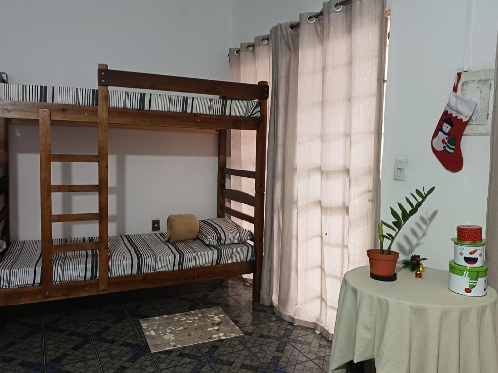 a room with two bunk beds and a table at Hostel Goiabeiras in Cuiabá