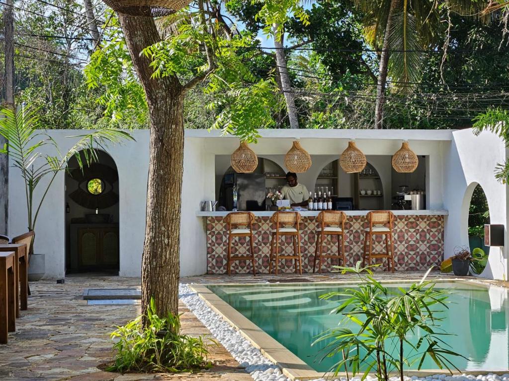 a resort with a swimming pool and a bar at Casa Carmen Hostel in Weligama