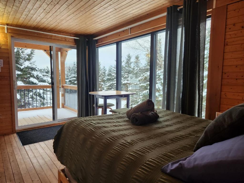 een slaapkamer met een bed met een teddybeer erop bij Chalet Beausite in Saint-Philémon