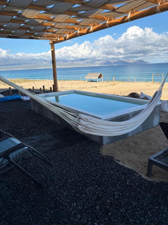 a hammock on the beach next to the ocean at Grand Ocean View Suite with Private Pool in La Paz