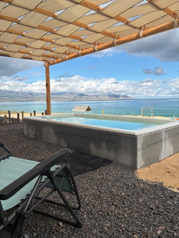 una piscina con una silla y el océano en Oceanfront Private Pool Villa Luxury Open-Concept Retreat, en La Paz
