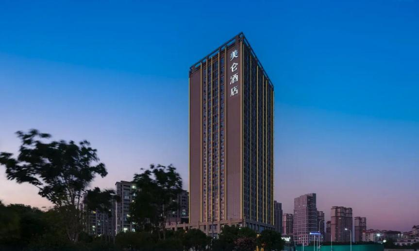 a tall building in front of a city skyline at Madison Hotel Wuxi Luocheng in Wuxi
