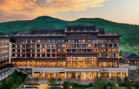 a large building with lights in front of a mountain at Steigenberger Hotel Jinan in Jinan