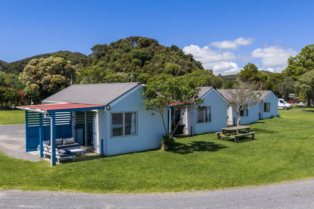 a blue house with a picnic table in the grass at Waitangi Holiday Park in Paihia
