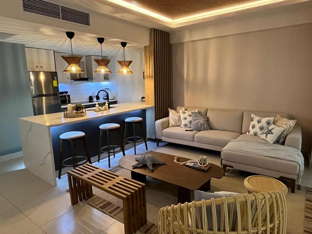 Una sala de estar y una cocina con un sofá y una mesa. en Las Olas Apartment, Juan Dolio, en Guayacanes