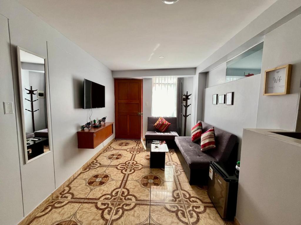 ein Wohnzimmer mit Sofa und Fernseher in der Unterkunft Cozy & Centric Apartment in great location! in Cusco