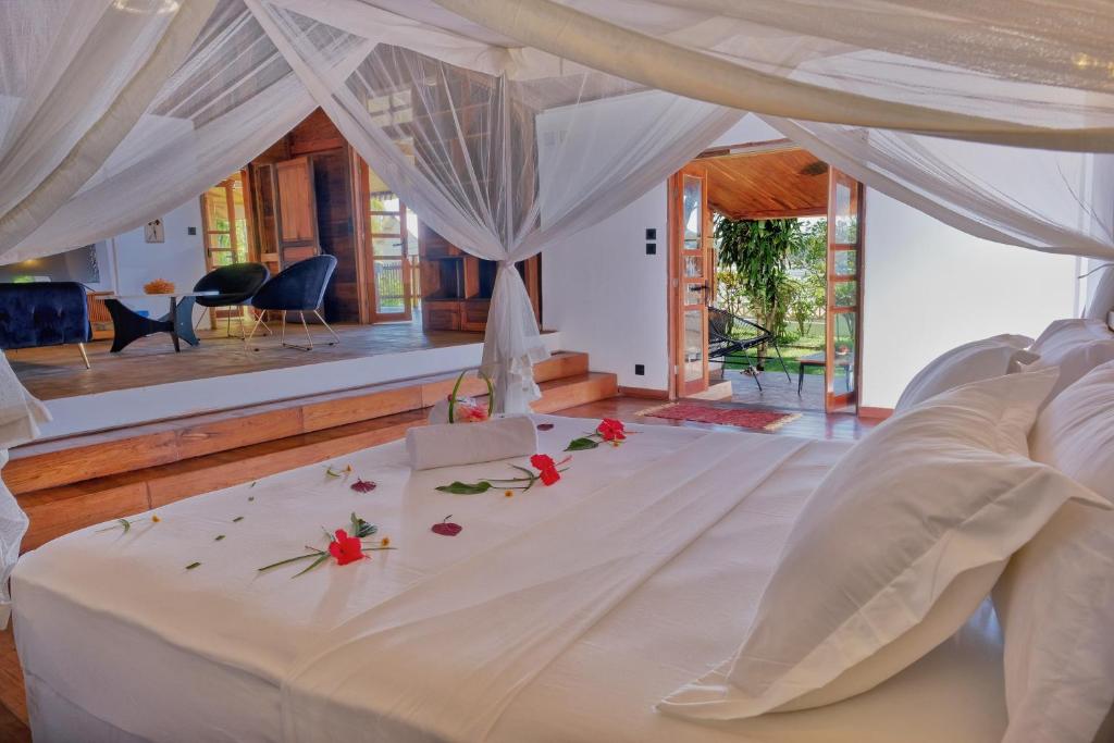 a bedroom with a bed with flowers on it at Beach Villa l'Heure Bleue in Madirokely