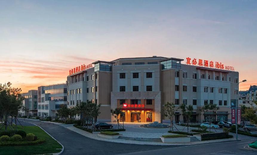 a building with a sign on the top of it at Ibis Dalian Yida Springfield in Dalian
