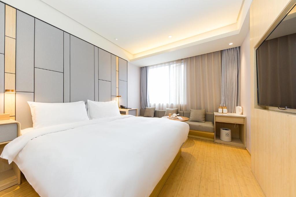 Ένα ή περισσότερα κρεβάτια σε δωμάτιο στο JI Hotel Shanghai Jing'an Temple Huaihai Middle Road